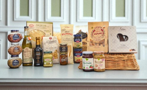 Luxury Italian corporate hamper filled with gourmet foods including pasta, olive oil, balsamic vinegar, artisan biscuits, preserves, and sweet treats, beautifully displayed with a wicker basket.